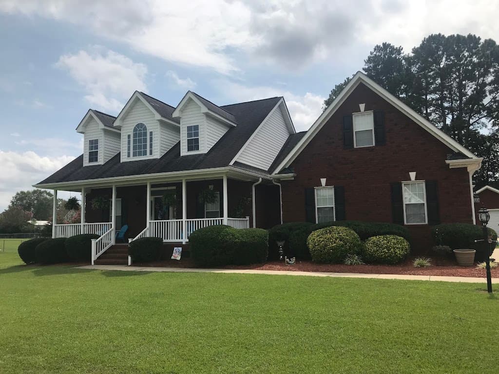 Trimmed hedges and manicured lawn in front of a brick home